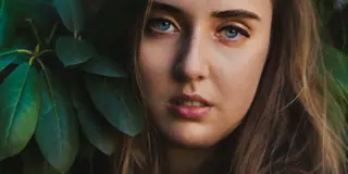 Portrait of a woman framed by green leaves